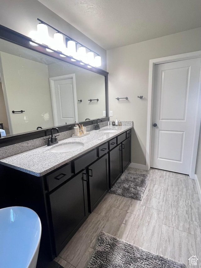bathroom featuring vanity, a textured ceiling, and hardwood / wood-style flooring