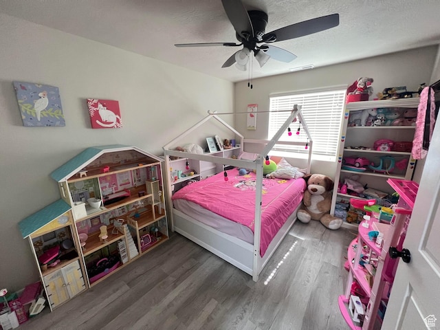 bedroom featuring ceiling fan, a textured ceiling, and hardwood / wood-style flooring