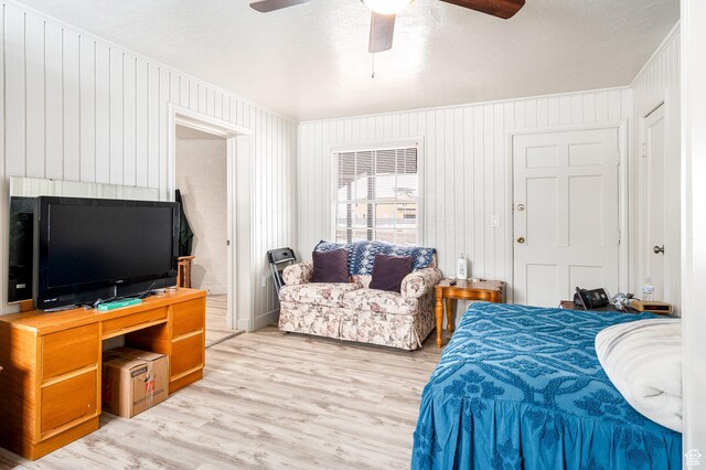 1180 S Cove View Rd, Richfield, UT 84701 - bedroom with ceiling fan, light hardwood / wood-style floors, a textured ceiling, and wooden walls