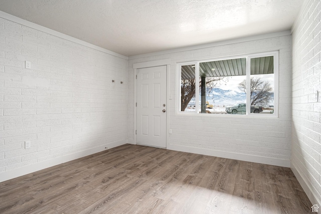1180 S Cove View Rd, Richfield, UT 84701 - empty room with hardwood / wood-style floors, a textured ceiling, and brick wall