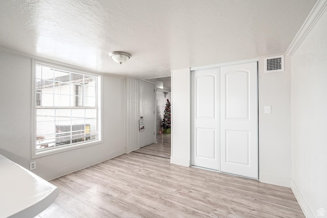 1180 S Cove View Rd, Richfield, UT 84701 - unfurnished bedroom featuring a textured ceiling, light hardwood / wood-style flooring, a closet, and ornamental molding
