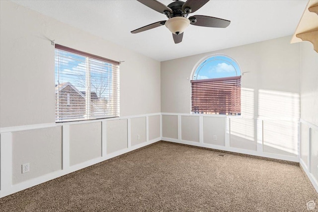 unfurnished room with carpet flooring, ceiling fan, and a healthy amount of sunlight