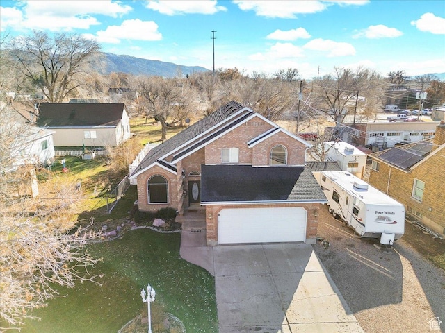 68 E 100 N, Nephi, UT 84648 - view of front of house featuring brick siding, a mountain view, driveway, a garage, and roof with shingles