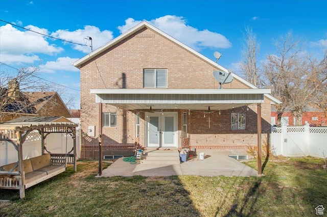 rear view of property featuring ceiling fan and a yard