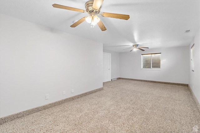 carpeted empty room featuring a textured ceiling