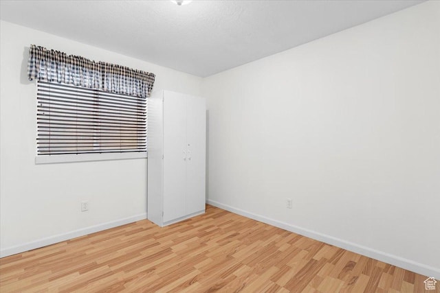 unfurnished room featuring a textured ceiling and light hardwood / wood-style floors