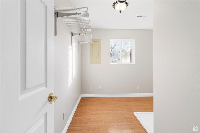 interior space featuring electric panel and light wood-type flooring