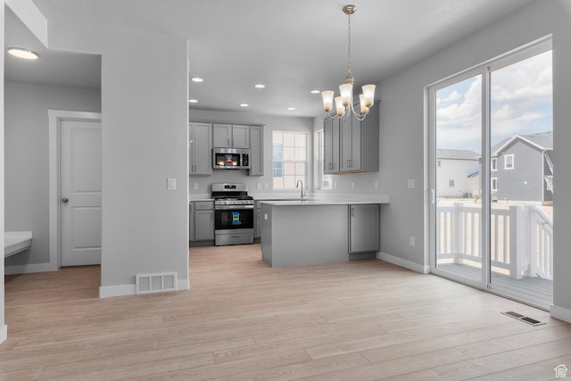 6636 W Prairie Fire Ln Unit 733, Herriman, UT 84096 - kitchen featuring pendant lighting, light hardwood / wood-style floors, gray cabinets, and stainless steel appliances