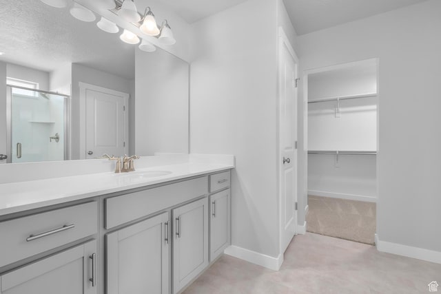 6636 W Prairie Fire Ln Unit 733, Herriman, UT 84096 - bathroom featuring a textured ceiling, vanity, and walk in shower