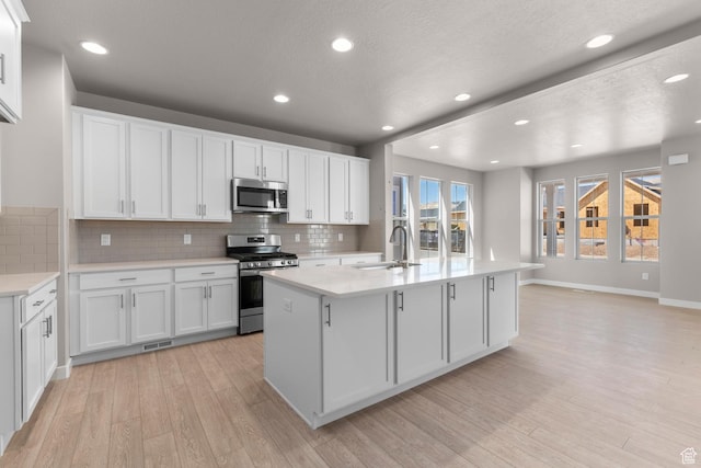 kitchen featuring white cabinets, stainless steel appliances, light hardwood / wood-style flooring, and sink