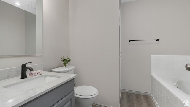 1583 E 1500 N, Logan, UT 84341 - bathroom with tiled tub, hardwood / wood-style floors, vanity, and toilet