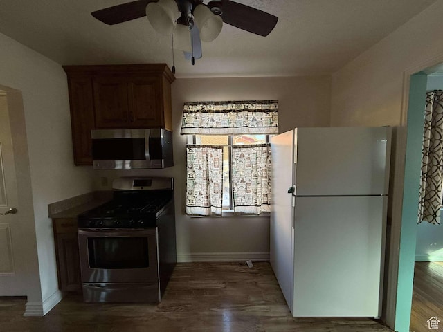kitchen with ceiling fan, dark hardwood / wood-style flooring, and stainless steel appliances