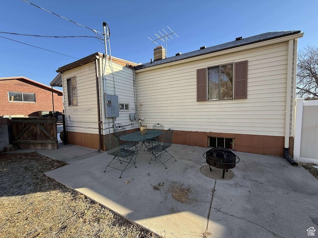 rear view of property with a patio area and an outdoor fire pit