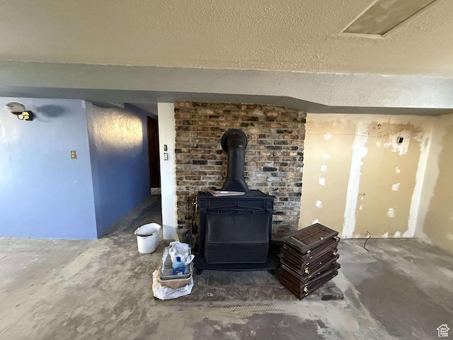 details featuring a wood stove, concrete floors, and a textured ceiling