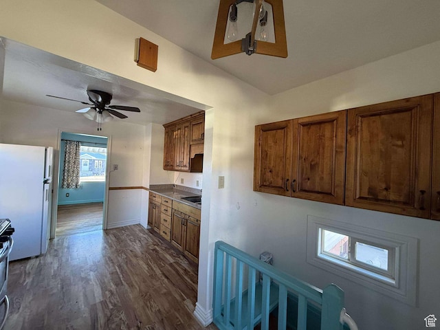 kitchen featuring sink, ceiling fan, stainless steel range, white fridge, and dark hardwood / wood-style flooring