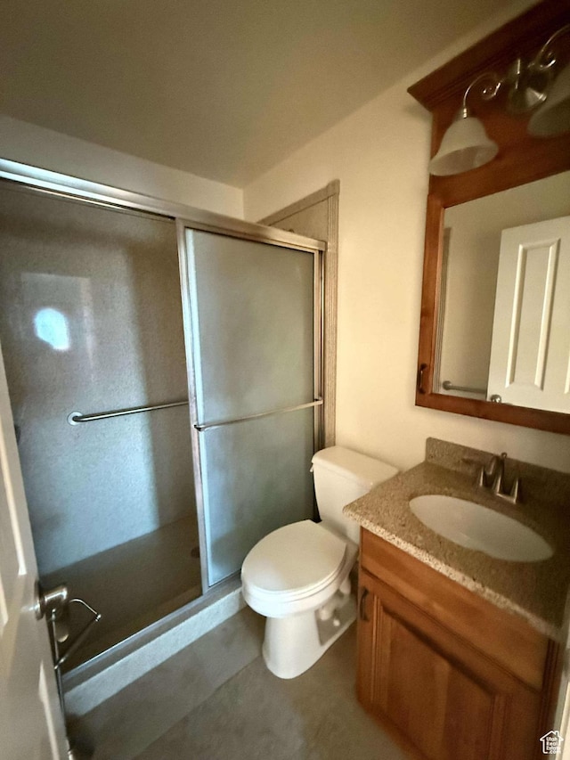 bathroom featuring toilet, vanity, and walk in shower