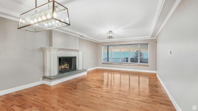 120 N 1400 E, Pleasant Grove, UT 84062 - unfurnished living room featuring wood finished floors, ornamental molding, a warm lit fireplace, and a chandelier