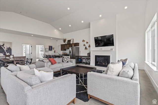 living room with light colored carpet and high vaulted ceiling