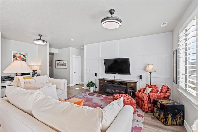 living room featuring light hardwood / wood-style floors and a textured ceiling