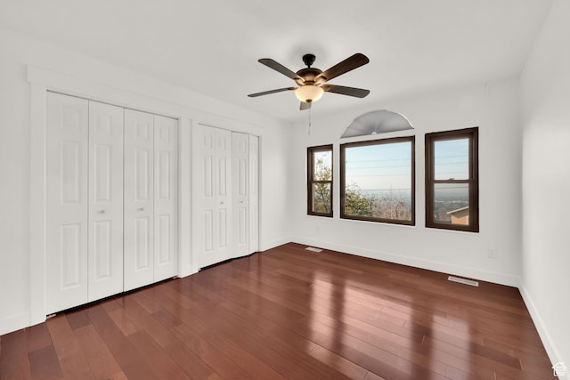 4821 S Fortuna Way, Salt Lake City, UT 84124 - unfurnished bedroom with dark wood-style floors, two closets, and baseboards