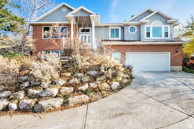 4821 S Fortuna Way, Salt Lake City, UT 84124 - ranch-style house featuring stucco siding, stairs, driveway, brick siding, and a garage