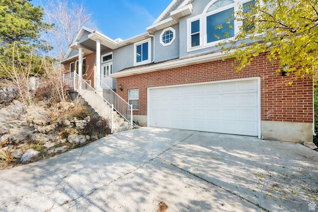 4821 S Fortuna Way, Salt Lake City, UT 84124 - view of front of property featuring brick siding, driveway, stairway, and an attached garage