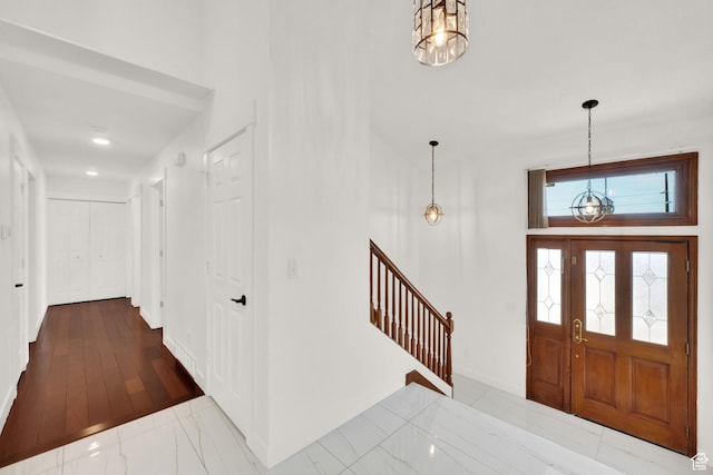 4821 S Fortuna Way, Salt Lake City, UT 84124 - foyer entrance featuring marble finish floor, baseboards, stairway, and an inviting chandelier