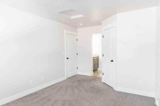 spare room with light colored carpet and baseboards