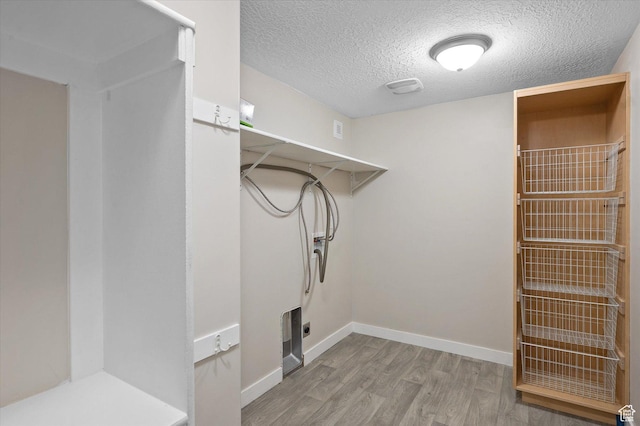 4487 W Tee Box Dr, South Jordan, UT 84009 - laundry room with wood finished floors, a textured ceiling, hookup for an electric dryer, and baseboards