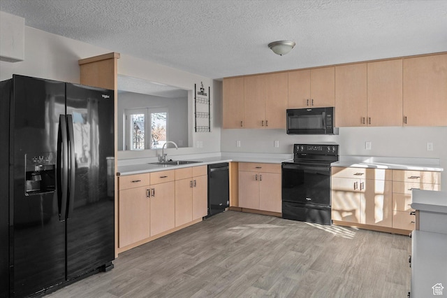 4487 W Tee Box Dr, South Jordan, UT 84009 - kitchen with black appliances, light brown cabinets, a sink, light wood-type flooring, and light countertops