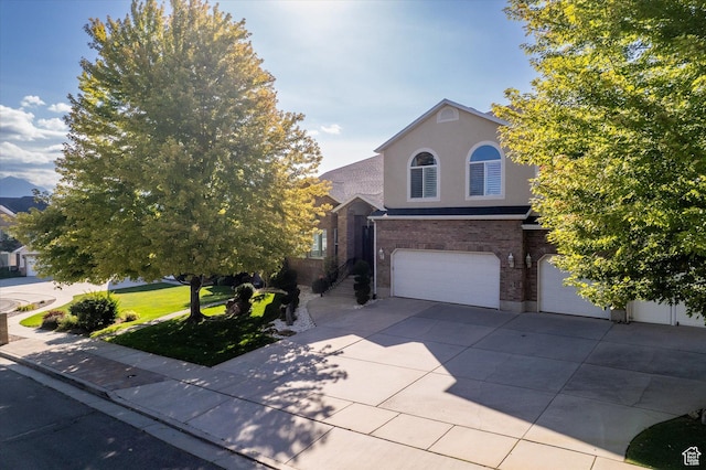 4487 W Tee Box Dr, South Jordan, UT 84009 - view of front of home with an attached garage, brick siding, stucco siding, and concrete driveway
