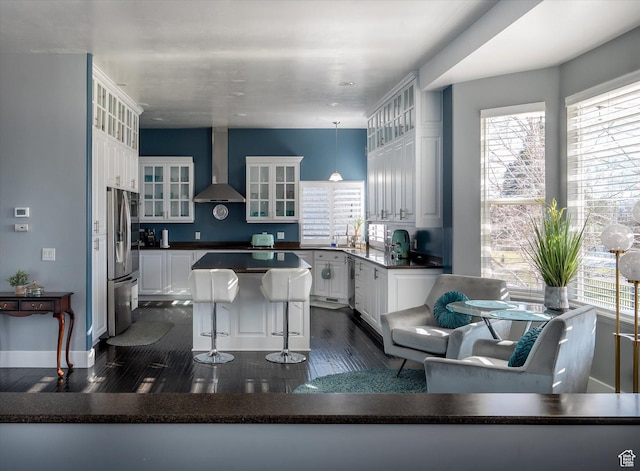 4487 W Tee Box Dr, South Jordan, UT 84009 - kitchen featuring wall chimney exhaust hood, stainless steel refrigerator with ice dispenser, white cabinets, a center island, and dark wood finished floors