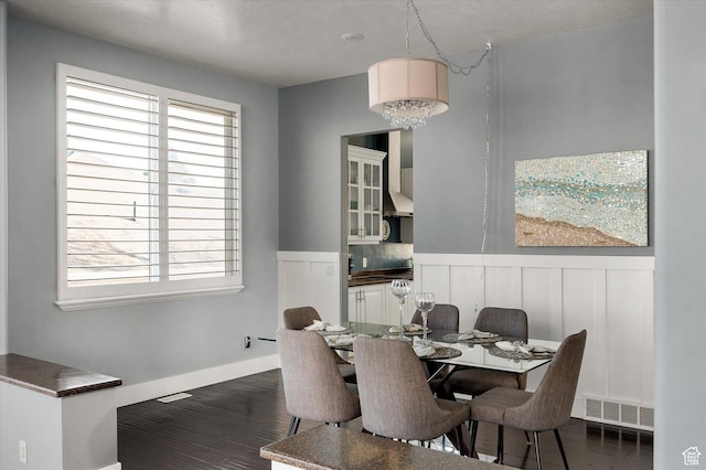 4487 W Tee Box Dr, South Jordan, UT 84009 - dining space with a wainscoted wall, a decorative wall, and dark wood-type flooring
