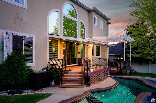 4487 W Tee Box Dr, South Jordan, UT 84009 - back of property at dusk featuring stucco siding, a deck, and a pergola