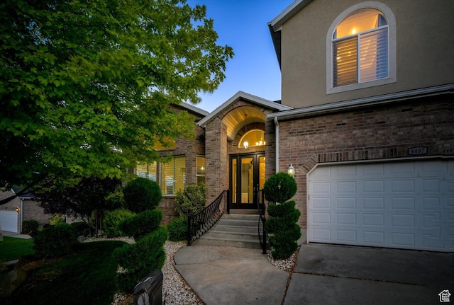 4487 W Tee Box Dr, South Jordan, UT 84009 - property entrance featuring brick siding, an attached garage, driveway, and stucco siding