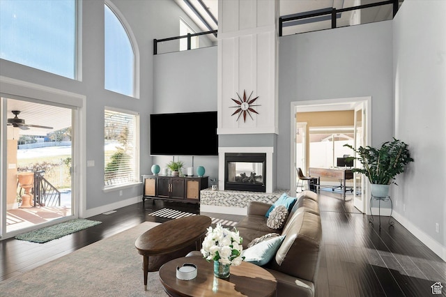 4487 W Tee Box Dr, South Jordan, UT 84009 - living area featuring a towering ceiling, a fireplace, baseboards, dark wood-type flooring, and ceiling fan