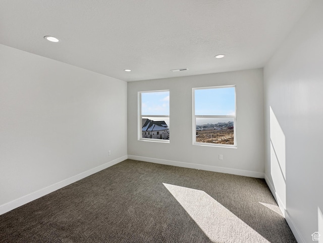 carpeted empty room featuring a textured ceiling