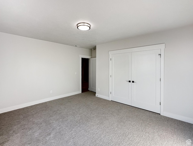 unfurnished bedroom with carpet flooring, a textured ceiling, and a closet