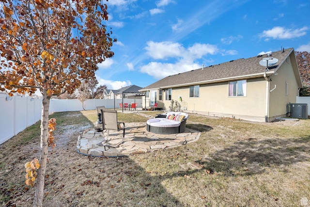 rear view of property featuring central air condition unit, stucco siding, a fenced backyard, a patio, and a yard
