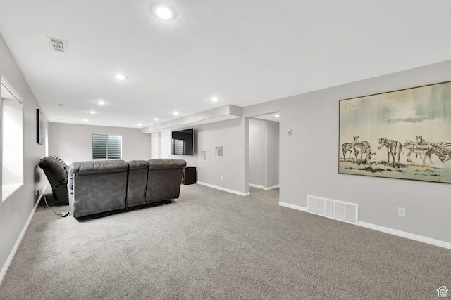 living room featuring light colored carpet, visible vents, and baseboards