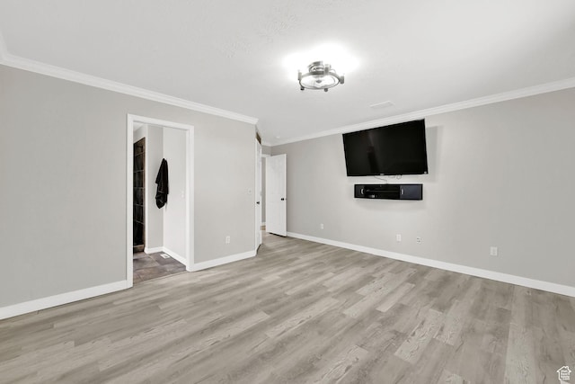 unfurnished living room with baseboards, wood finished floors, and ornamental molding
