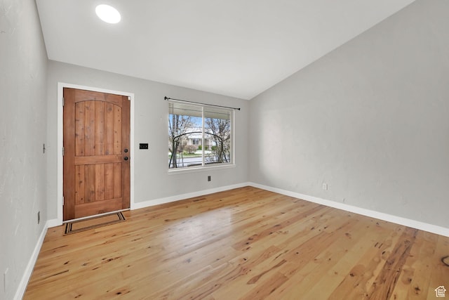 entrance foyer featuring baseboards, lofted ceiling, and wood-type flooring