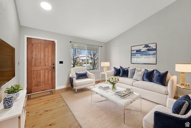 living room with baseboards, vaulted ceiling, and wood finished floors