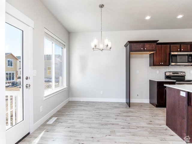 16297 S Truss Dr Unit 614, Bluffdale, UT 84065 - kitchen with an inviting chandelier, hanging light fixtures, decorative backsplash, appliances with stainless steel finishes, and light hardwood / wood-style floors