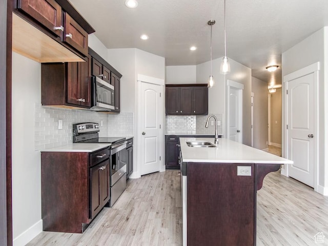16297 S Truss Dr Unit 614, Bluffdale, UT 84065 - kitchen with sink, stainless steel appliances, decorative light fixtures, dark brown cabinets, and light wood-type flooring