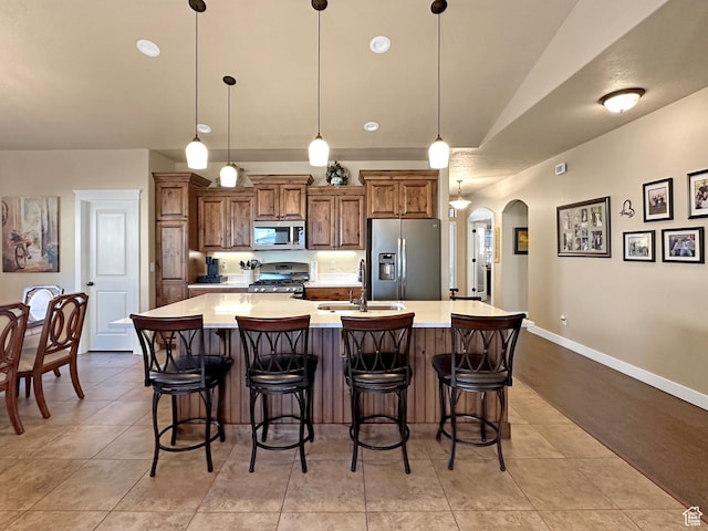1313 N 250 E, Brigham City, UT 84302 - kitchen with appliances with stainless steel finishes, a sink, arched walkways, a large island with sink, and light countertops