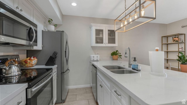 kitchen featuring sink, light tile patterned flooring, decorative light fixtures, white cabinets, and appliances with stainless steel finishes