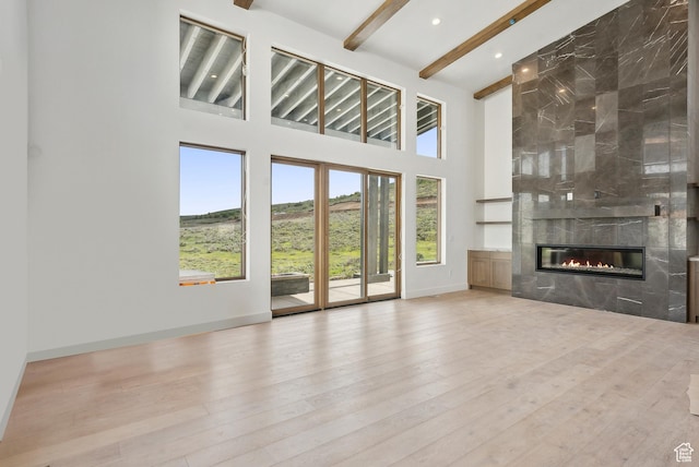 5758 Cobalt Cir Unit 12, Park City, UT 84098 - unfurnished living room with beamed ceiling, a fireplace, a towering ceiling, baseboards, and wood finished floors