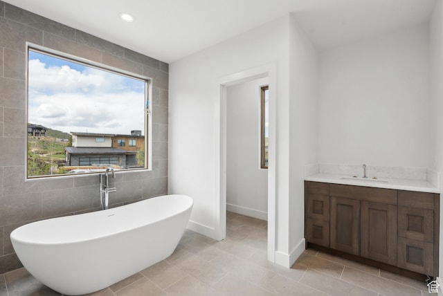 5758 Cobalt Cir Unit 12, Park City, UT 84098 - bathroom featuring a soaking tub, baseboards, tile walls, vanity, and tile patterned flooring