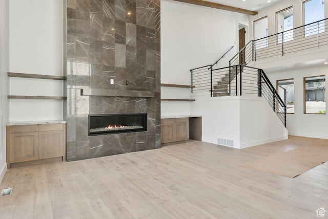 5758 Cobalt Cir Unit 12, Park City, UT 84098 - unfurnished living room featuring stairway, a tiled fireplace, wood finished floors, a high ceiling, and baseboards